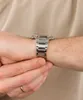 A close-up shot of a person's wrist wearing a silver watch. Náhľad obrázku produktu