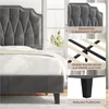 A close-up view of a dark gray upholstered bed frame with a tufted headboard, showcasing its construction and details. Produktbild-Vorschau
