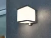 A modern anthracite LED wall light with a motion sensor mounted on a textured gray wall. Anteprima dell’immagine prodotto