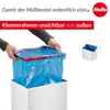 Hands are shown inserting a blue trash bag into a white bin with a red clamp. Anteprima dell’immagine prodotto