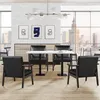 A modern dining room or office space with a white brick wall, large windows overlooking a city skyline, a dining table with chairs, and artwork on the wall. Produktbild-Vorschau