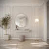 A modern entryway or dressing area with a round mirror, a floating shelf, a stool, a plant, and a floor lamp. Náhled obrázku produktu