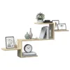 A modern, zig-zag shaped wall shelf unit made of wood-look material, displayed against a white background. It is decorated with various items including books, vases, a plant, framed pictures, and a clock. Náhled obrázku produktu