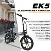 A black electric bicycle is shown in front of a building with flowers. Voir les images du produit