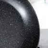 A close-up view of the speckled interior of a black frying pan. Podgląd zdjęcia produktu