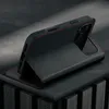 A black leather iPhone case with red stitching is shown in a studio setting, propped up to display its stand feature. Anteprima dell’immagine prodotto