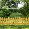 A wooden picket fence in a garden with green grass and trees in the background. Náhled obrázku produktu