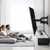 A couple is playing video games in a living room, with a TV mounted on the wall. Anteprima dell’immagine prodotto
