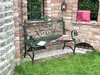 A green metal garden bench is placed in a brick alcove with a window and a lantern. Anteprima dell’immagine prodotto