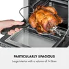 A hand holding a rotisserie spit with a roasted chicken on it, being inserted into an oven. The oven interior and a drip tray are visible. Náhľad obrázku produktu