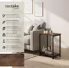 A side table next to a sofa in a living room setting, with marketing text on the left side. Produktbild-Vorschau