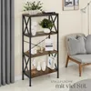 A tall, narrow bookshelf with items displayed on its shelves, placed in a room next to a sofa and curtains. Produktbild-Vorschau