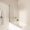 A modern bathroom with a bathtub and a glass shower screen. Podgląd zdjęcia produktu