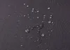 Water droplets on a dark gray textured surface. Produktbild-Vorschau
