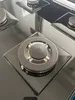 A close-up view of a gas stove burner on a black glass surface. Produktbild-Vorschau