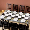 A dining table set with plates, bowls, and cutlery, ready for a meal. Produktbild-Vorschau