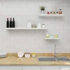 A kitchen scene with white tiled walls and a marble countertop. Produktbild-Vorschau