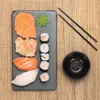 A top-down view of a sushi set arranged on a dark slate platter, placed on a bamboo mat. Náhled obrázku produktu