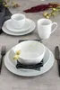 A table setting with white porcelain dishes, cutlery, and decorative dried flowers. Produktbild-Vorschau