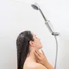 A woman is taking a shower with a shower filter attached to the shower head. Produktbild-Vorschau