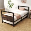 A twin bed with a pull-out trundle bed underneath, set up in a room with wooden flooring and a plant. Náhled obrázku produktu