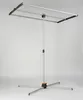 A freestanding clothes drying rack with a silver frame and black and orange accents, set against a plain light gray background. Anteprima dell’immagine prodotto