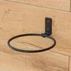 A black metal plant pot holder is mounted on a wooden wall. Náhľad obrázku produktu