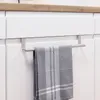 A stainless steel towel rack is attached to the front of a white kitchen cabinet, holding a gray and white striped kitchen towel. Produktbild-Vorschau