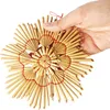 A hand holding a straw star ornament against a white background. Produktbild-Vorschau