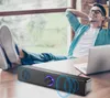 A man relaxing with his feet up on a desk, listening to music from a soundbar. Voir les images du produit