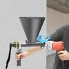 A person is using a mortar gun to apply material to a textured wall. Podgląd zdjęcia produktu