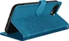 A blue flip case for a smartphone, with a mandala design embossed on the cover, is shown in a standing position. Podgląd zdjęcia produktu