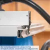 A close-up view of a table saw's fence and guide mechanism, with a vacuum hose visible in the background. Produktbild-Vorschau