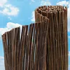 Two rolled-up reed fences are shown against a blue sky with white clouds. Produktbild-Vorschau