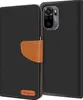A black flip case for a smartphone, with a brown leather strap and a small brown logo on the bottom left. Náhled obrázku produktu