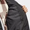 Close-up of the inside of a black jacket, showing the lining and a hand reaching into a pocket. A plaid shirt is visible underneath the jacket. Voir les images du produit