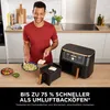 A man is preparing food in a kitchen with an air fryer. Produktbild-Vorschau