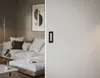A modern living room with a sofa and a sliding door with a black handle. Produktbild-Vorschau