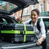 A woman loading luggage into the trunk of a car. Podgląd zdjęcia produktu