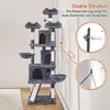 A tall, multi-level cat tree with various platforms, scratching posts, and enclosed spaces, shown in a room setting with a wall and floor. Inset images demonstrate how to secure the cat tree to the wall for stability. Podgląd zdjęcia produktu