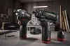 Two cordless drills and accessories are displayed on a workbench in a workshop setting. Produktbild-Vorschau