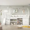 A child's bedroom with a white loft bed featuring a slide, stairs, and built-in storage. The walls are painted a light green and decorated with clouds, hot air balloons, and a giraffe poster. Toys and books are visible in the storage units. Podgląd zdjęcia produktu