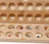A close-up view of a wooden board game with small colorful stones in its pits. Podgląd zdjęcia produktu