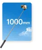 A selfie stick extended against a blue sky with clouds, with a person taking a selfie at the top. Voir les images du produit