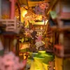 A miniature diorama of a Japanese street scene with cherry blossoms and a cartoon character. Náhled obrázku produktu