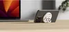 A smartphone with a MagSafe accessory attached is placed on a wooden surface next to a laptop. Produktbild-Vorschau