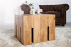 A wooden coffee table in a living room setting with a sofa in the background. Produktbild-Vorschau