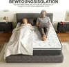 A couple on a bed, one sleeping and the other using a laptop. Produktbild-Vorschau
