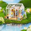 A miniature greenhouse model with plants and gardening tools, set in a miniature garden landscape with a pond. Anteprima dell’immagine prodotto