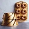 A set of gold-colored Bundt cake pans, with two individual pans stacked in the foreground and a six-cup Bundt pan in the background. Podgląd zdjęcia produktu